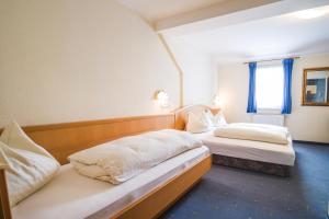 twee bedden in een hotelkamer met een raam bij Landhaus Gretl by S4Y in Krumpendorf am Wörthersee