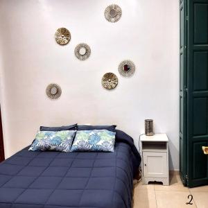 - une chambre avec un lit et quelques miroirs sur le mur dans l'établissement Apartamento Mon Chéri, à Malaga
