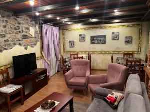 - un salon avec un canapé, des chaises et une télévision dans l'établissement CASA PELENTOS Sandinies, à Sandiniés