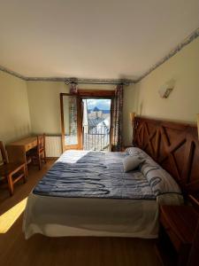 1 dormitorio con 1 cama, ventana y escritorio en CASA PELENTOS Sandinies, en Sandiniés