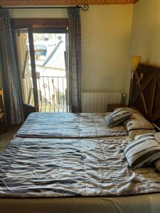 a large bed in a room with a window at CASA PELENTOS Sandinies in Sandiniés