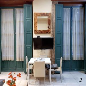 une salle à manger avec des portes vertes et une table avec des chaises dans l'établissement Apartamento Mon Chéri, à Malaga