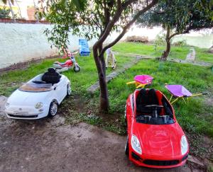 Casa Vacanze "Villa Severina" IUN R6166 R6692 في كاربونيا: سيارتين صغيرتين متوقفتين بجانب شجرة