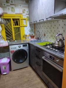 a kitchen with a stove and a washing machine at 锦江LoveMyHome in Almaty