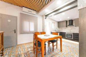 a kitchen with a wooden table and chairs at La Sagrera House in Barcelona