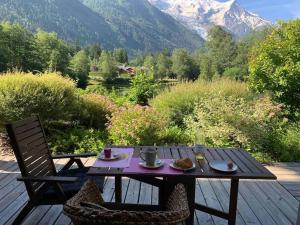 a table and chairs on a deck with a view of a mountain at La Belle Cordee SPA lujo y piscina CHAMONIX in Chamonix-Mont-Blanc