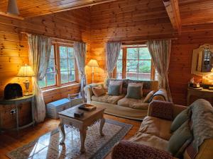 ein Wohnzimmer mit einem Sofa und einem Tisch in der Unterkunft Forest Lodge Log Cabin - Ireland in Ballyconnell