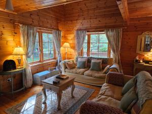 een woonkamer met een bank en een tafel bij Forest Lodge Log Cabin - Ireland in Ballyconnell