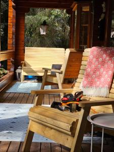 a wooden bench sitting on a porch with a table at Forest Lodge Log Cabin - Ireland in Ballyconnell