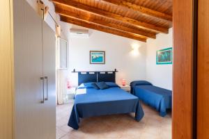 1 dormitorio con 2 camas y sábanas azules en Villetta Fiore B&B, en Cutrofiano