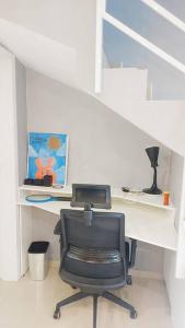 una scrivania con sedia nera in una stanza bianca di Casa linda, luxo e aconchegante a Blumenau