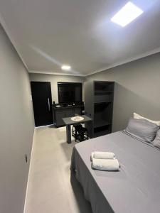 een slaapkamer met een bed, een bureau en een tafel bij Hospedagem Confortável e Prática para viajantes e férias - Próxima à BR-101 in São José