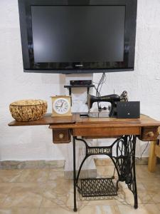 einen Schreibtisch mit einem TV darüber in der Unterkunft Old House Kontic in Nikšić