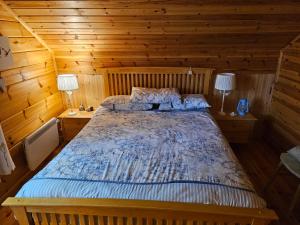 una camera con un letto in una cabina di legno di Forest Lodge Log Cabin - Ireland a Ballyconnell