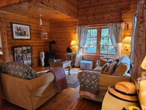 a living room with two couches in a log cabin at Forest Lodge Log Cabin - Ireland in Ballyconnell