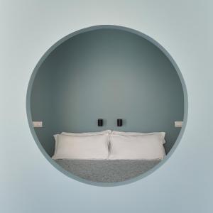 espejo que refleja una cama con almohadas blancas en UP to home - Residenze Milano, en Milán