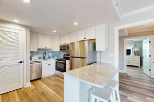 a kitchen with white cabinets and a marble counter top at OC Condo 4100 #103 in Ocean City