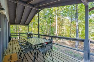 a patio with a table and chairs on a deck at Cabin w Hot Tub, Huge Deck, Firepit & WiFi! in Hedgesville