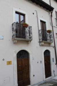 a white building with two doors and two balcony at La Dimora di Ziella in Barisciano