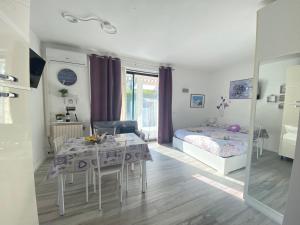 - un salon avec une table et un lit dans l'établissement Appartamento “La casetta di Mirto”, à Porlezza