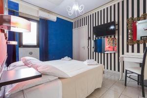 加提歐馬里的住宿－Le Cinema Gatteo Mare，一间卧室配有一张床、一张桌子和一台电视。