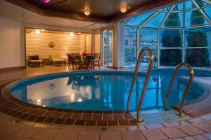 a large swimming pool in a house with a patio at Home Hotel Smedjan in Sandviken