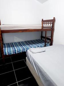 a bunk bed in a room next to at Casa inteira em chácara, 20 min centro. in Curitiba
