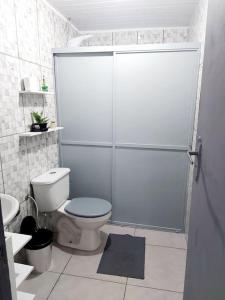 a bathroom with a shower with a toilet and a sink at Casa inteira em chácara, 20 min centro. in Curitiba