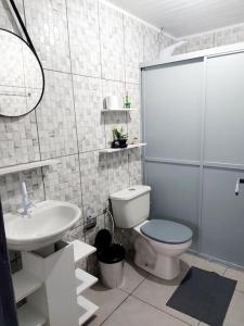 a bathroom with a toilet and a sink at Casa inteira em chácara, 20 min centro. in Curitiba