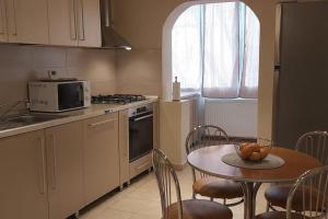 a kitchen with a table and a microwave and a table and chairs at Apartment Dan Timisoara - two bedrooms in Timişoara