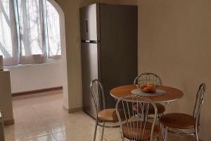 a kitchen with a table and chairs and a refrigerator at Apartment Dan Timisoara - two bedrooms in Timişoara