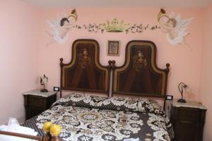 a bedroom with a bed with a crown on the wall at La Dimora di Ziella in Barisciano