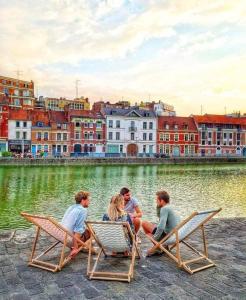 a group of people sitting in lawn chairs by the water at Le Nouveau Moulin by concierge city in Lille