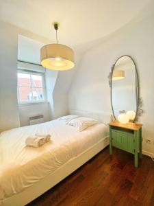 a bedroom with a bed with a mirror and a table at Le Nouveau Moulin by concierge city in Lille