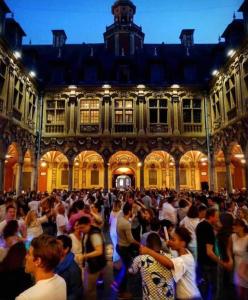 Une foule nombreuse de personnes se tenant devant un bâtiment dans l'établissement Le Nouveau Moulin by concierge city, à Lille