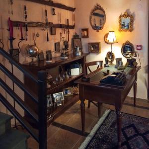 a room with a desk and a staircase with many items at Αρχοντικό Άννα Μαρία - Βουργαρέλι Τζουμέρκα in Vourgareli