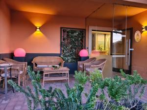 un patio con mesas y sillas de mimbre frente a un restaurante en Hotel Cladan en Asís
