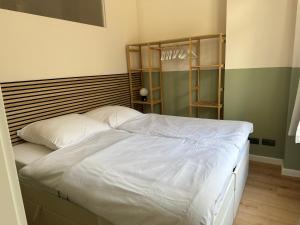 a bedroom with a white bed with a wooden headboard at Luxury in center of Berlin Mitte in Berlin