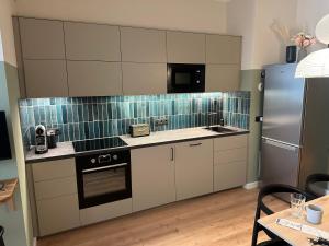 a kitchen with white cabinets and a stainless steel refrigerator at Luxury in center of Berlin Mitte in Berlin