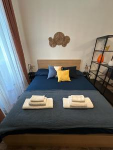 una camera da letto con un letto blu e asciugamani di Etna charme apartment a Catania