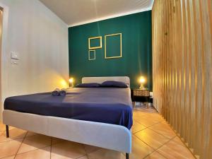 1 dormitorio con cama y pared verde en [FIERA] Bologna Expo Home en Bolonia