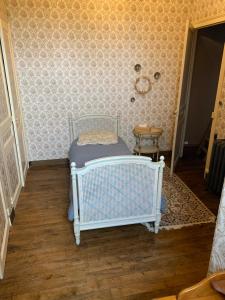 sypialnia z łóżeczkiem dziecięcym w pokoju z tapetą w obiekcie Château de la Franceule - la petite w mieście Janzé