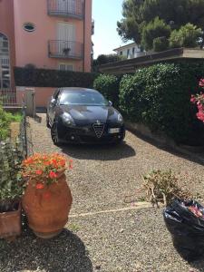 czarny samochód zaparkowany na podjeździe domu w obiekcie A due passi dal mare w mieście Castiglioncello
