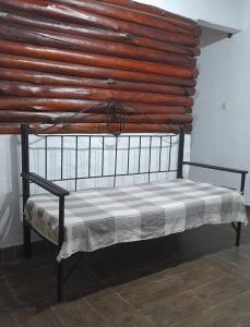 Bett in einem Zimmer mit einer Holzwand in der Unterkunft dulce claudina in Mercedes