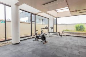 a gym with a exercise bike in a room with large windows at Akros Galapagos Suite in Quito