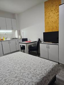 een kamer met een bed, een tafel en een keuken bij Apartmani Borko 3-1 in Loznica