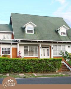 a large white house with a green roof at Full house, 11BR, 12BA, 10 min from SJO Airport in Heredia