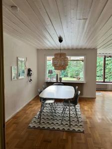a dining room with a white table and chairs at Cozy house near the sea in Höllviken