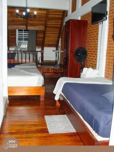 1 dormitorio con 2 camas y TV de pantalla plana en Full house, 11BR, 12BA, 10 min from SJO Airport, en Heredia