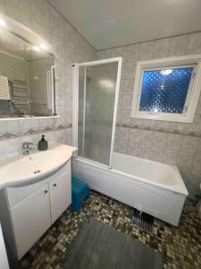 y baño con bañera, lavamanos y ducha. en Cozy house near the sea en Höllviken
